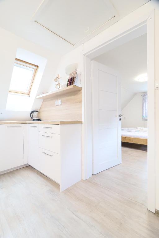 a kitchen with white cabinets and a skylight at Pension Adel in Český Krumlov