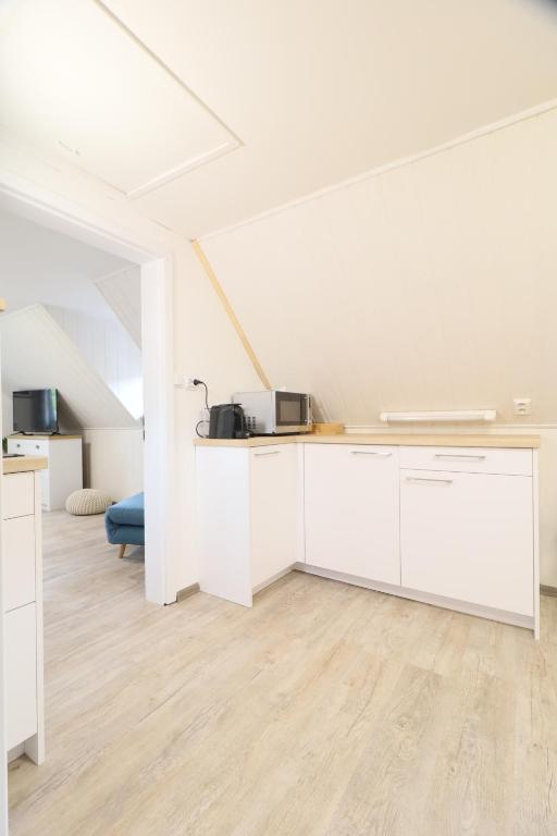 a kitchen with white cabinets in a room at Pension Adel in Český Krumlov
