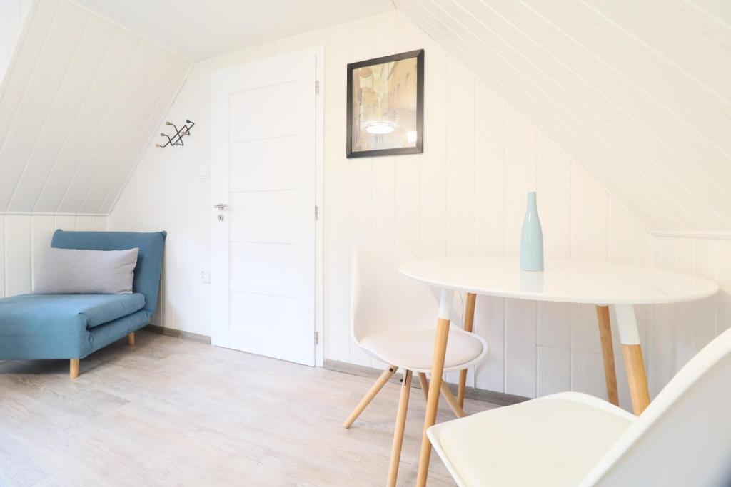 a living room with a table and a blue chair at Pension Adel in Český Krumlov