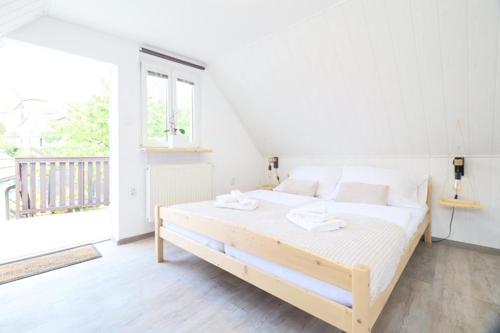 a bedroom with a bed with white sheets and a window at Pension Adel in Český Krumlov