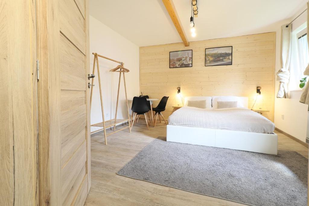 a bedroom with a white bed and a desk at Pension Adel in Český Krumlov