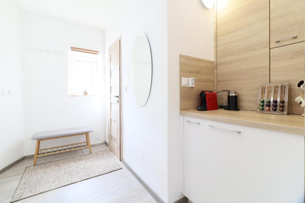 a kitchen with white walls and a counter with a stool at Pension Adel in Český Krumlov