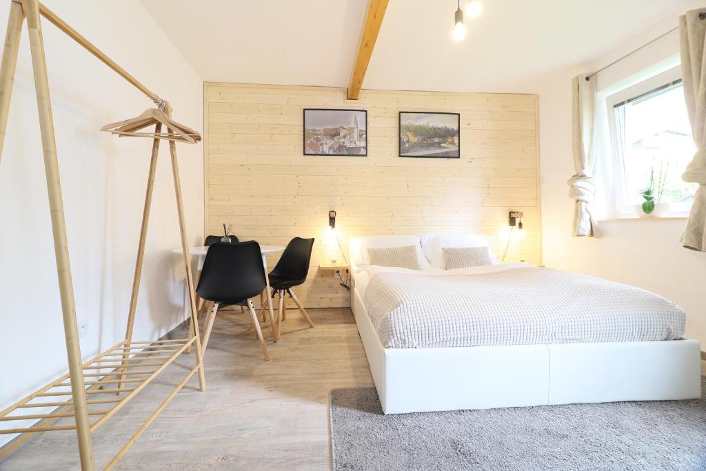 a bedroom with a white bed and a table and chairs at Pension Adel in Český Krumlov