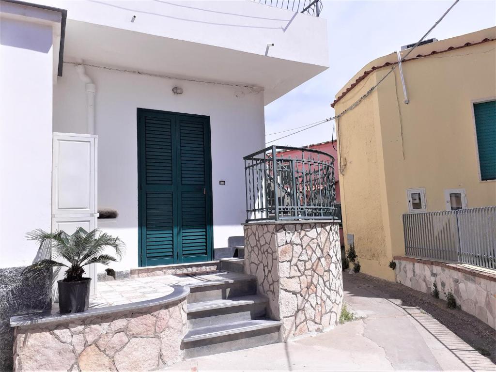 a house with a green door and stairs at da Letizia in Procida