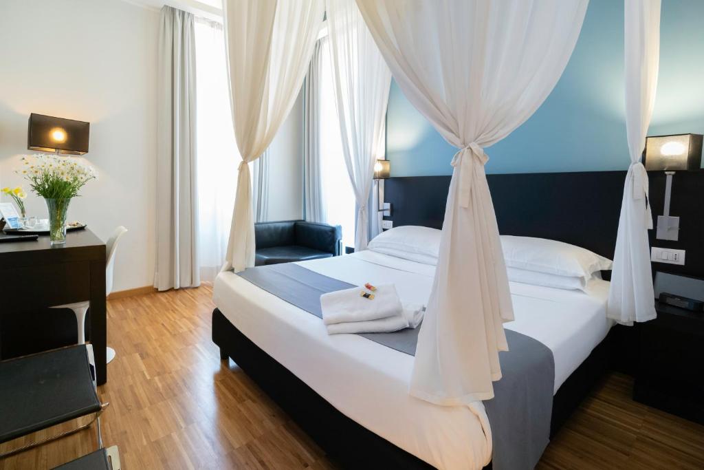 1 dormitorio con 1 cama blanca con dosel en At Home Townhouse - Filiberto, en Roma