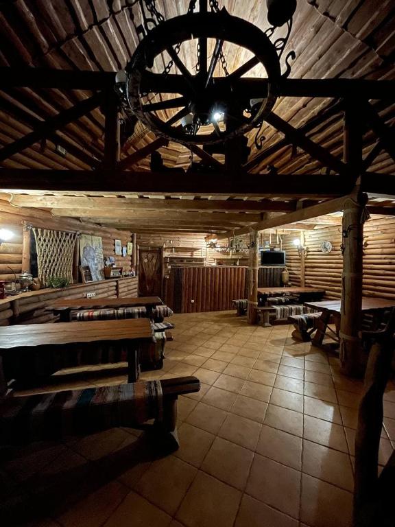 ein Zimmer mit Bänken und einem Kronleuchter in einem Gebäude in der Unterkunft Садиба у Попа in Lumshory