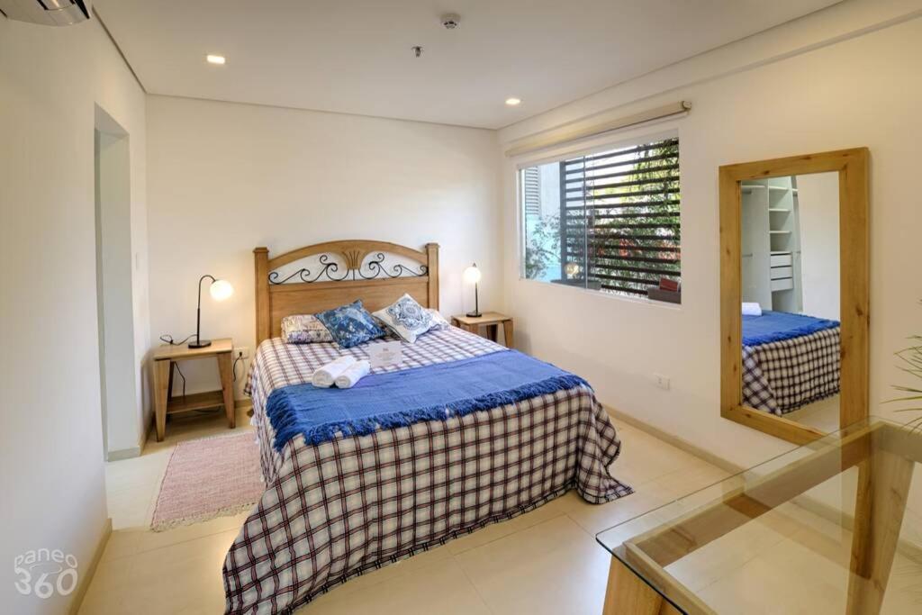 1 dormitorio con 1 cama grande y espejo en N4A2 - New, Nice, for Long and Short Stay, en Asunción