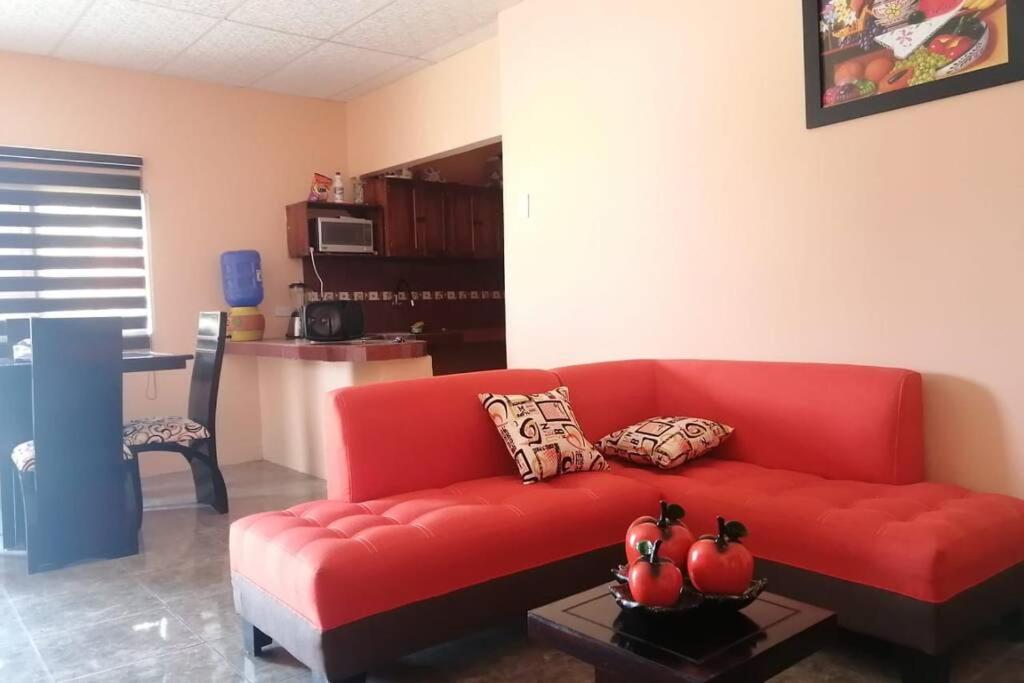 un sofá rojo en una sala de estar con mesa en Casa Independiente Ideal para Familias, en La Libertad