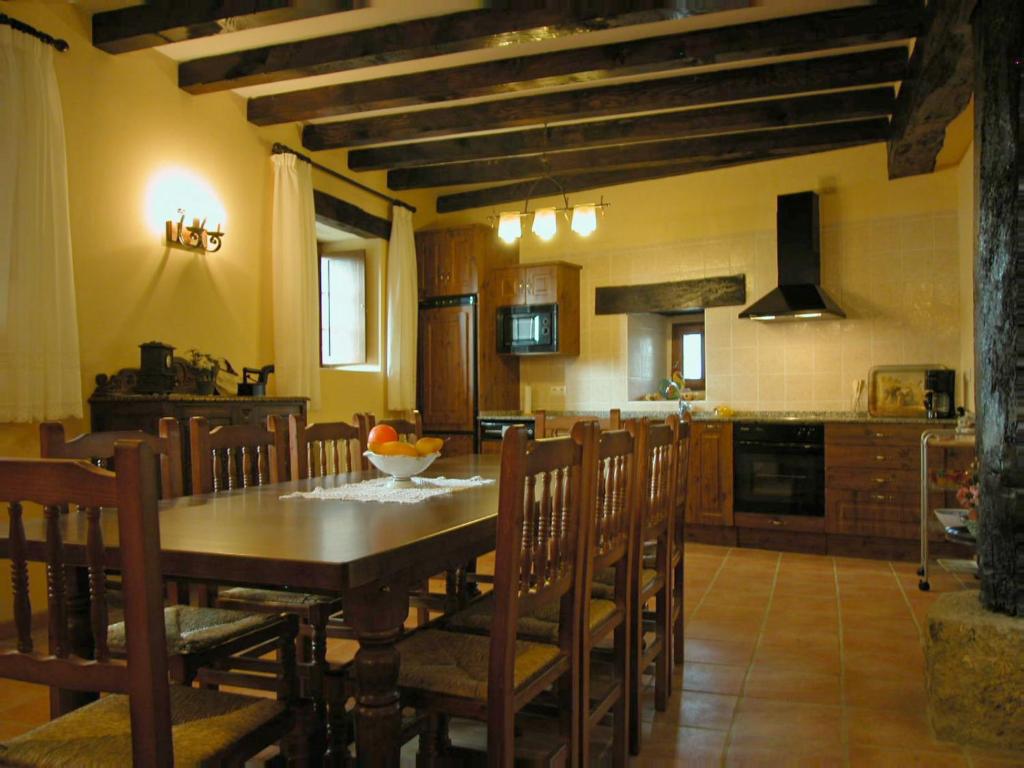 cocina y comedor con mesa y sillas en casa rural JUANSERENA, en Echarren