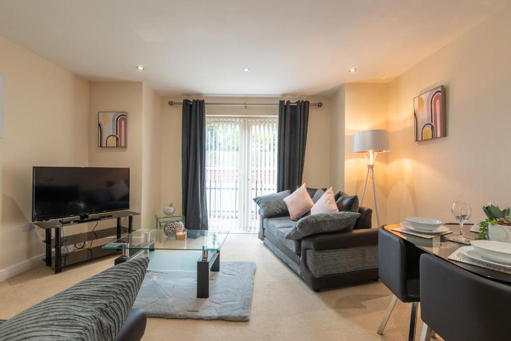 a living room with a couch and a tv at Apartment 5 in Worksop