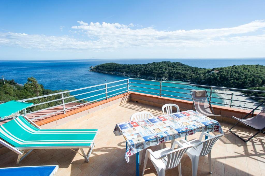 een balkon met een tafel en stoelen en de oceaan bij Villa La Terrazza sul Mare - Goelba in Fetovaia