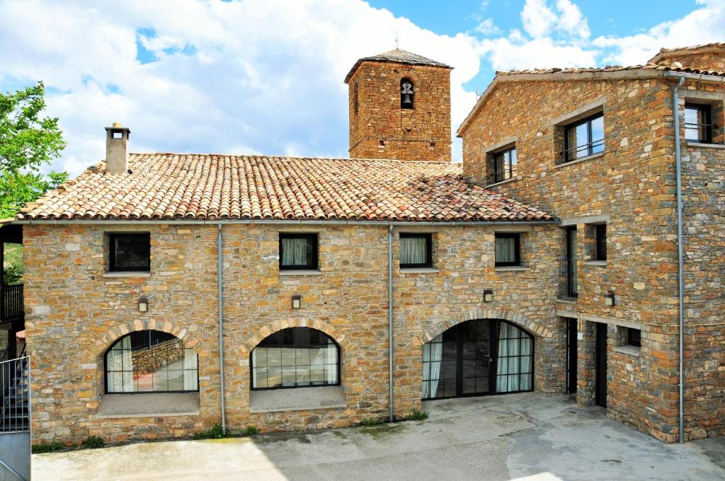 um velho edifício de tijolos com uma torre no topo em Rectoria de Claverol em Claverol