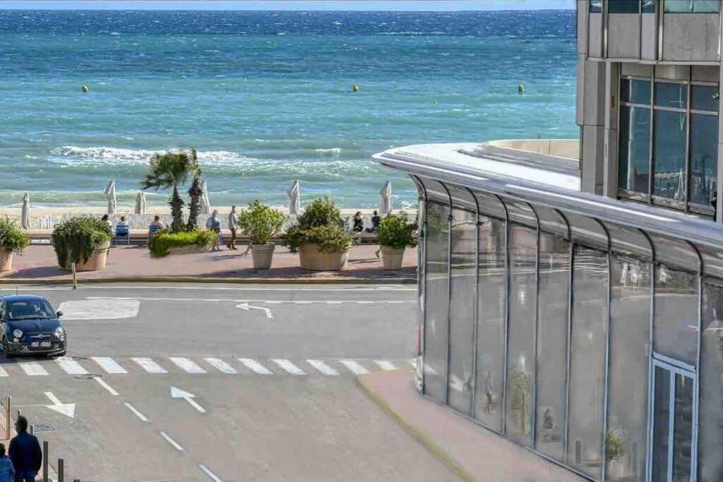 ein Auto, das eine Straße am Meer entlang fährt in der Unterkunft Somptueux logement,Cannes Croisette,4 Étoiles**** in Cannes
