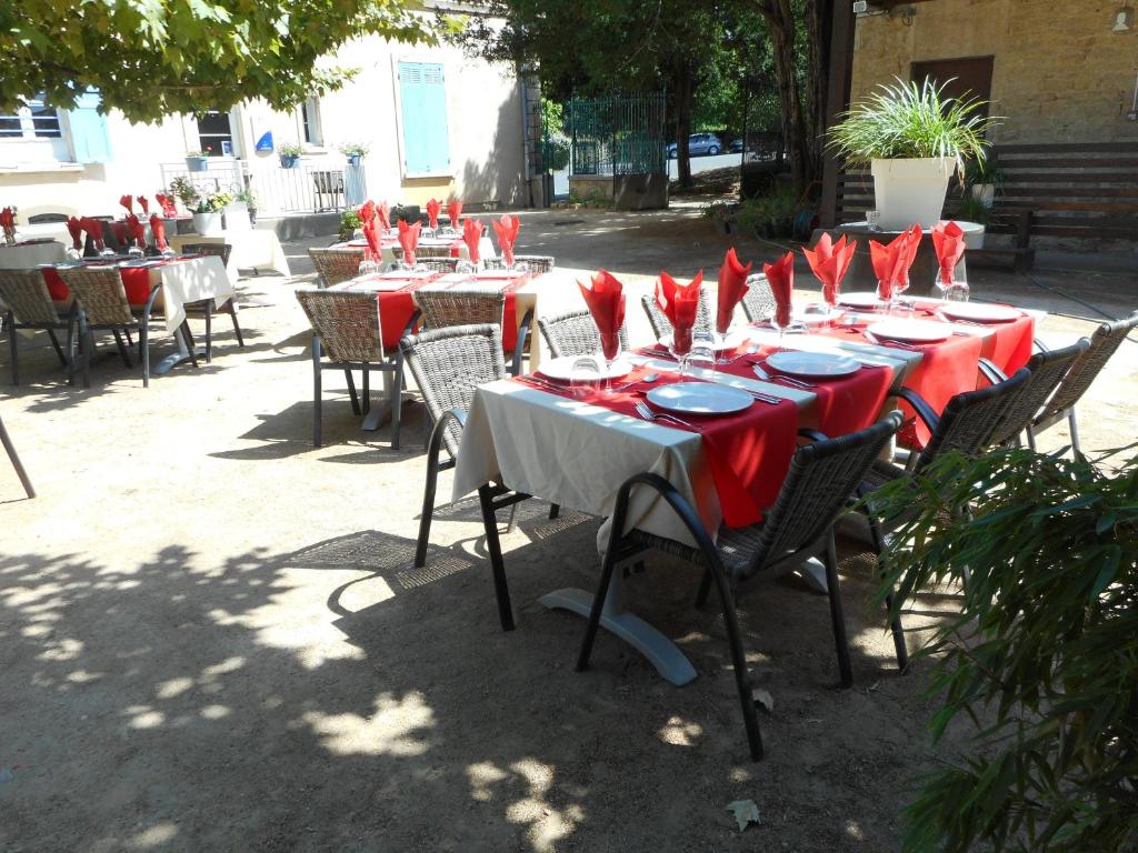 un grupo de mesas con servilletas y sillas rojas en VTF Le Domaine Les Hautannes, en Saint-Germain-au-Mont-dʼOr