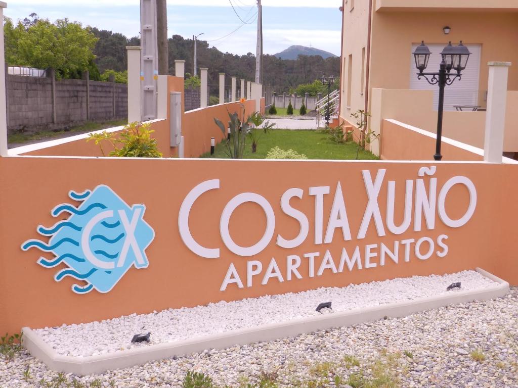 a sign for the entrance to a building at APARTAMENTOS COSTA XUÑO in Porto do Son