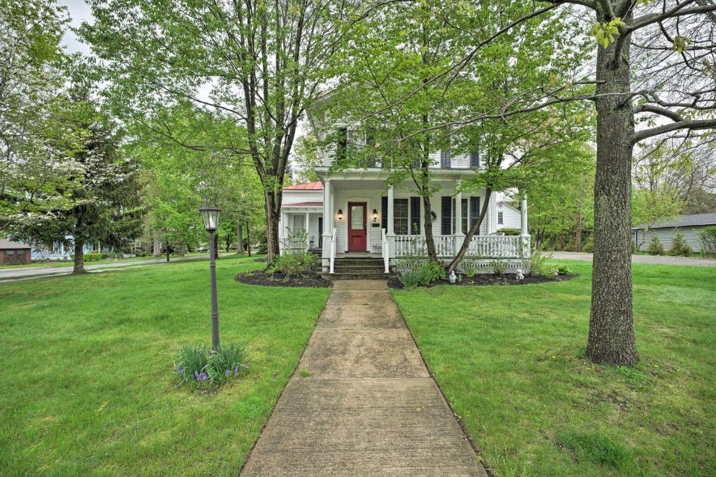 ein weißes Haus mit einer roten Tür im Hof in der Unterkunft Historic Westfield Home 2 Mi to Lake Erie! in Westfield