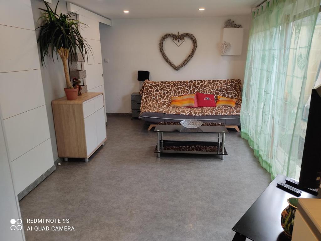 een woonkamer met een bank en een hartspiegel bij GLAM in Saint-Jean-dʼArvey
