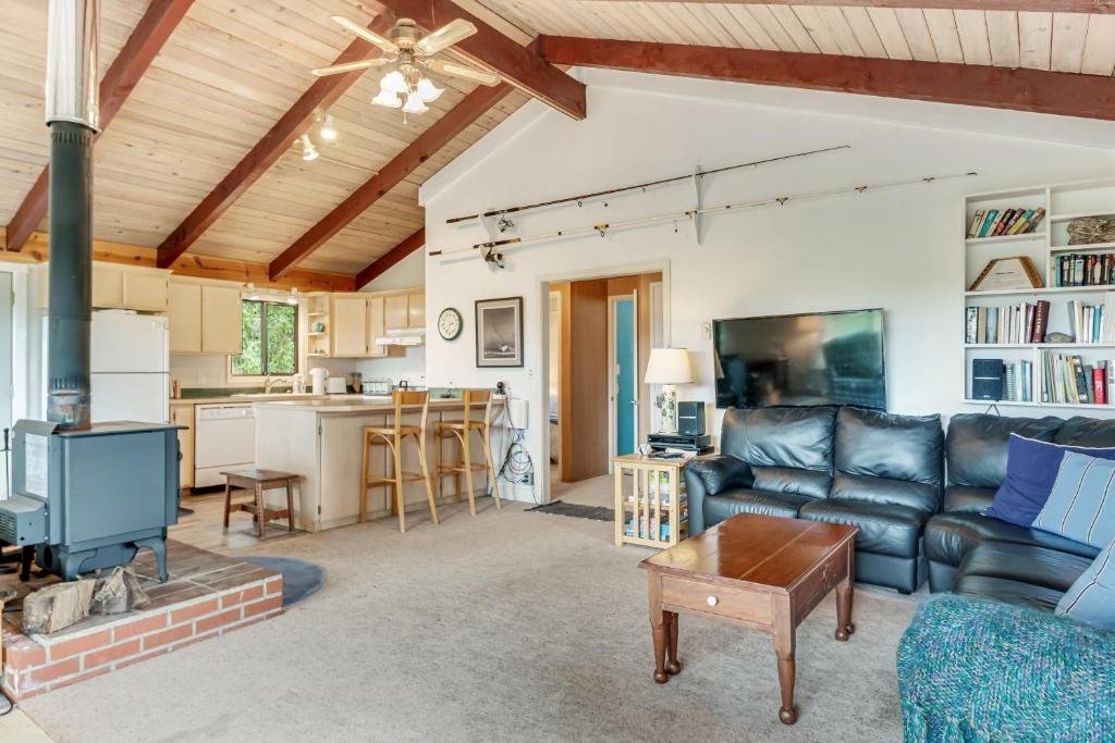 a living room with a couch and a kitchen at Dune Grass Cottage in Copalis Beach