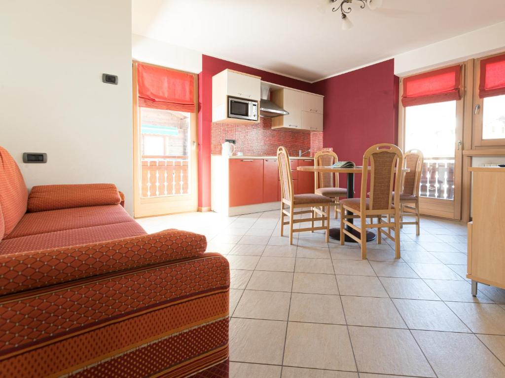 un soggiorno con divano, tavolo e sedie di Chalet Kiara - Appartamenti Abar a Livigno