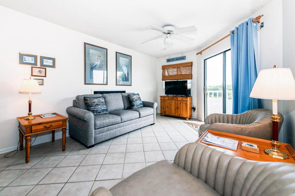 a living room with two couches and a tv at Bay Creek Villa - 202 in Edisto Beach