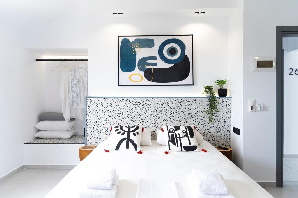 a bedroom with a white bed with black and white pillows at Seaside Suites in Kavos