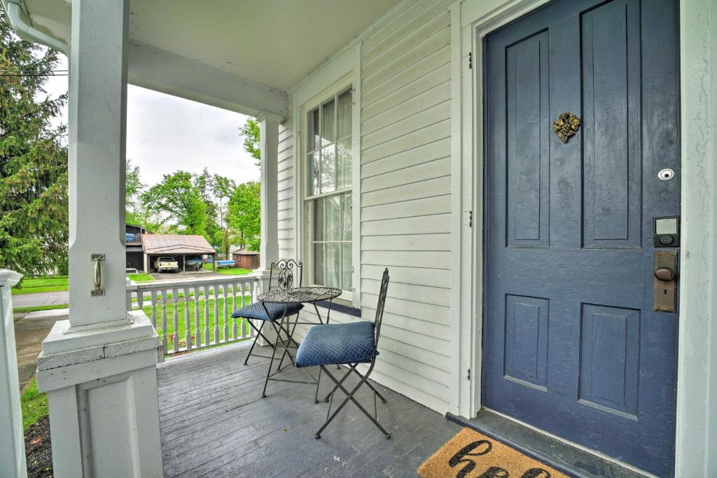 eine blaue Tür auf einer Veranda mit einem Tisch und Stühlen in der Unterkunft Romantic Apt Near Wineries, Golf and Lake Erie! in Westfield