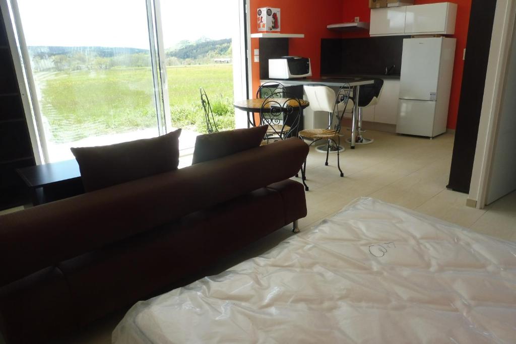 a living room with a couch and a large window at Chez Brigitte, un séjour en Haute-Loire in Saint-Germain-Laprade