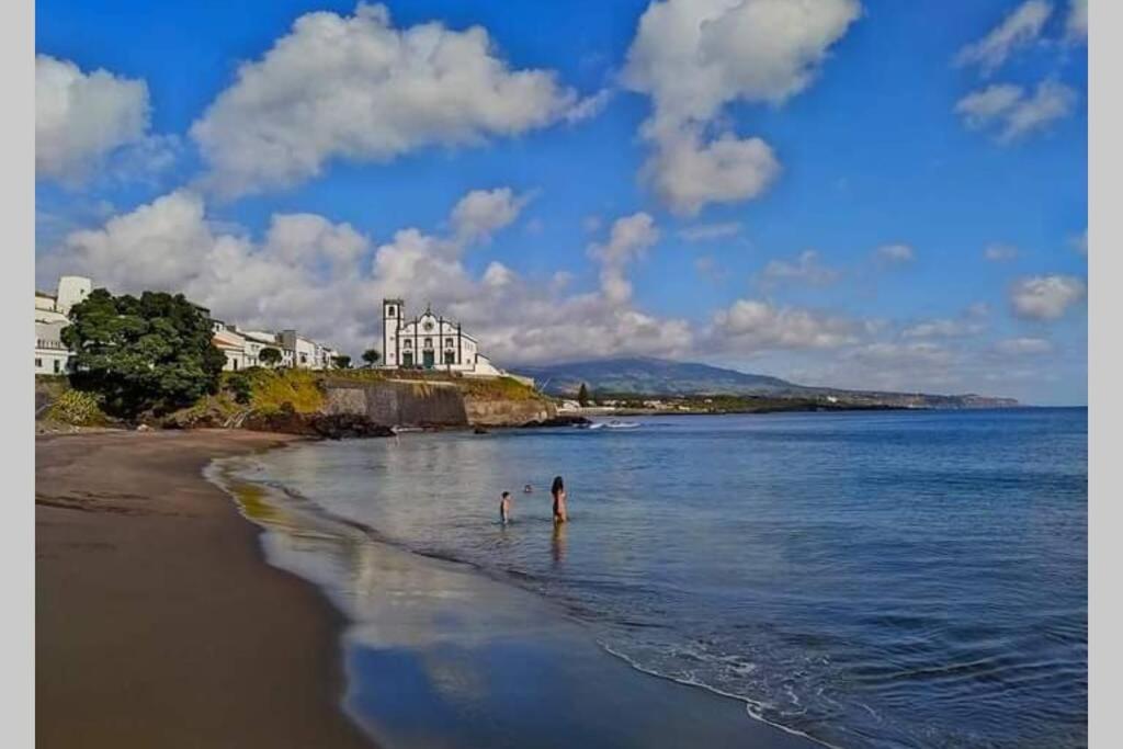 zwei Personen stehen im Wasser am Strand in der Unterkunft Casa de São Roque Açores in Ponta Delgada