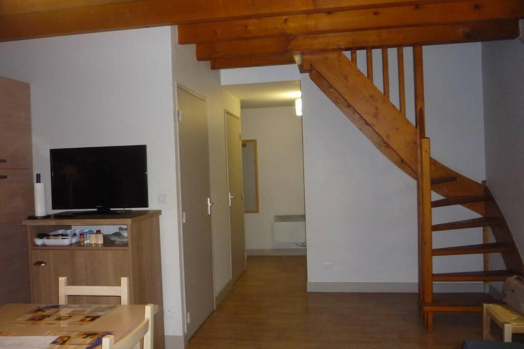 sala de estar con escalera y TV en Appartement en duplex pour 8 personnes en Arreau