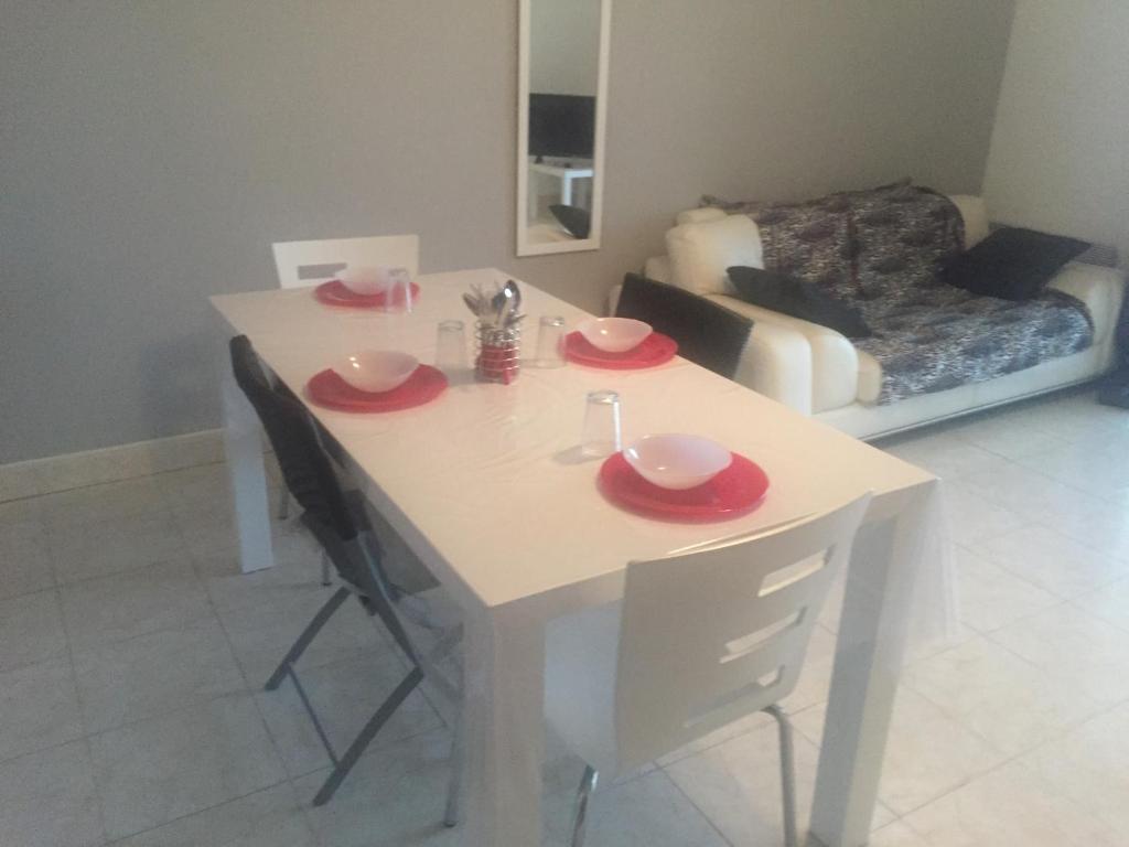 uma mesa branca com placas vermelhas numa sala de estar em LE CARAYON em Valras-Plage