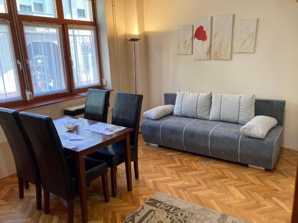 Halkoz Apartment في ديبريتْسين: غرفة معيشة مع طاولة وأريكة