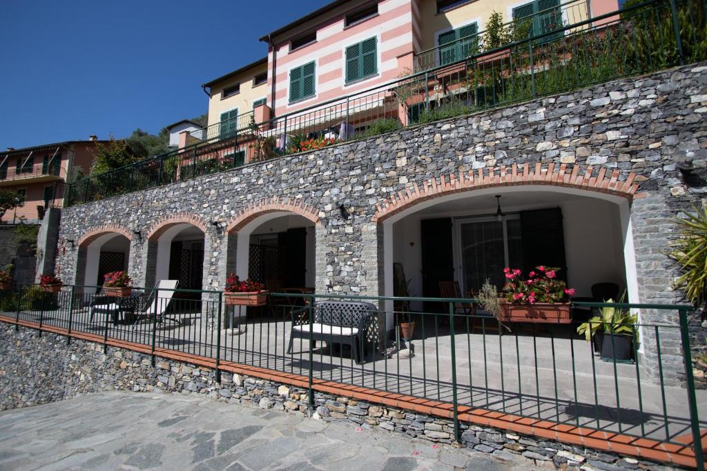 eine Backsteinmauer mit einem Zaun vor einem Gebäude in der Unterkunft un posto al sole in Molino Nuovo