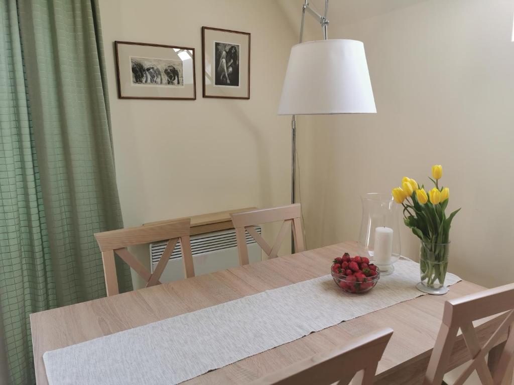 uma mesa de jantar com um vaso de flores em Apartament z kogutem em Zakopane