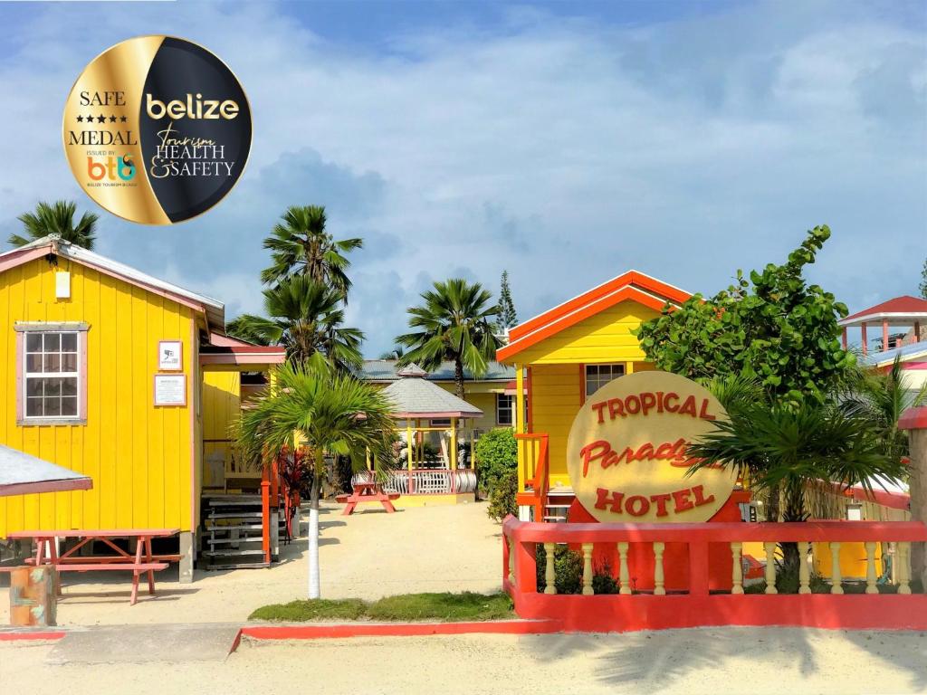 a yellow building with a sign in front of it at Tropical Paradise in Caye Caulker