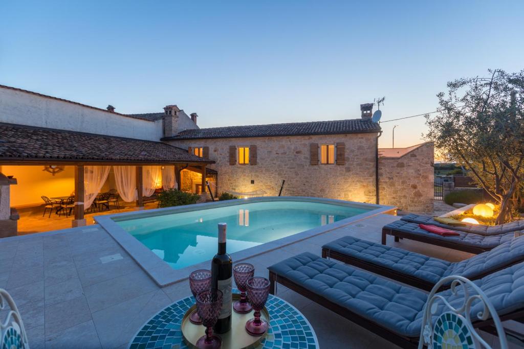 a villa with a swimming pool in front of a house at Casa Jagoda in Višnjan