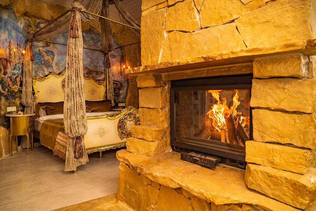 a stone fireplace in a room with a bed at Lethe Exclusive Hotel in Ağva