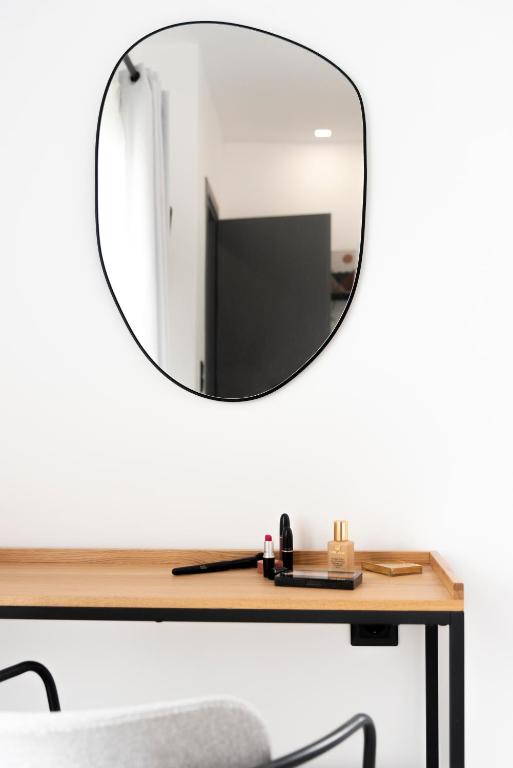 a mirror on top of a wooden table with a chair at Seaside Suites in Kavos