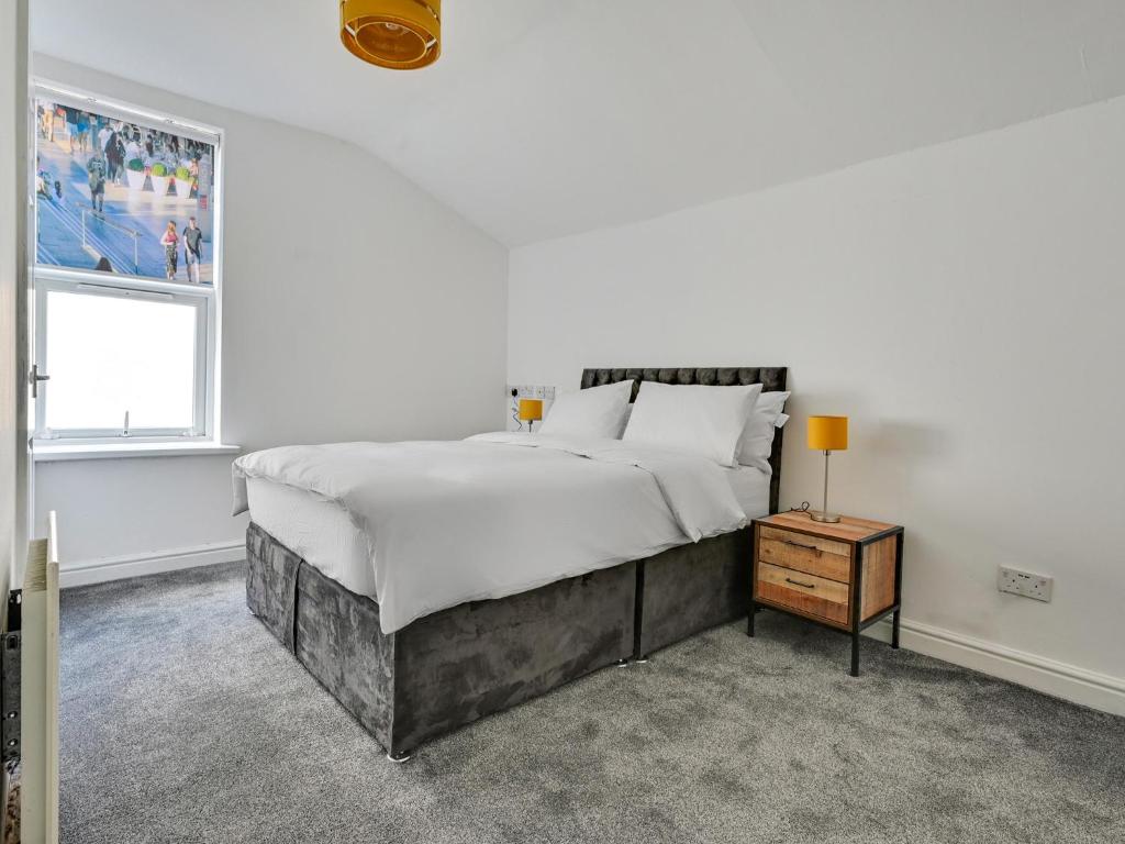 a white bedroom with a large bed and a window at Albert View Rooms in Manchester