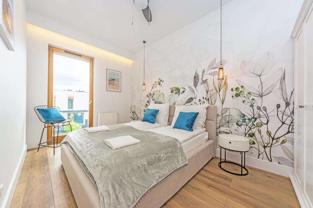 sypialnia z dużym łóżkiem z niebieskimi poduszkami w obiekcie Pomorskie Apartamenty Bernadowska Silver w mieście Gdynia