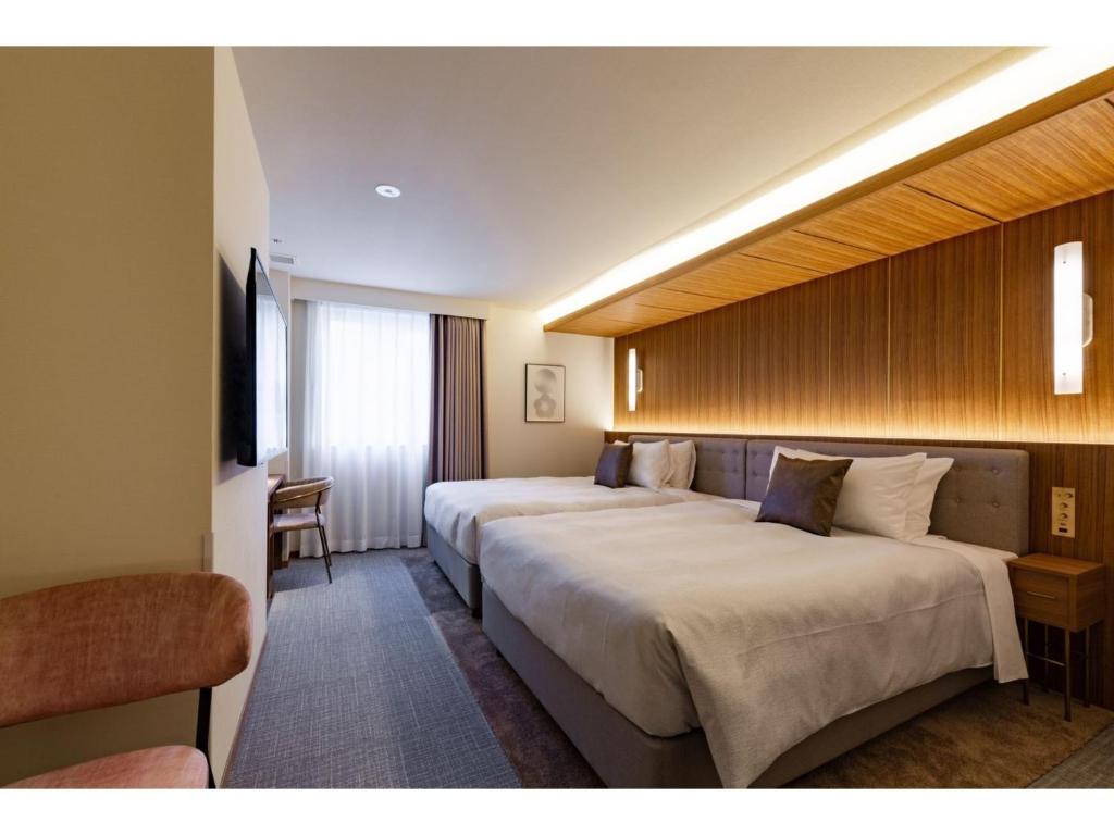 Habitación de hotel con 2 camas y TV en The OneFive Terrace Fukuoka - Vacation STAY 33433v, en Fukuoka