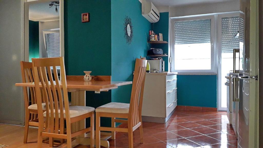 uma cozinha com mesa e cadeiras num quarto em Apartman TIN em Varaždin