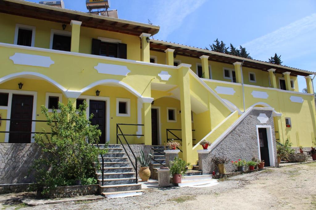 una casa gialla con le scale di fronte di Marina 1990 ad Agios Georgios Pagon