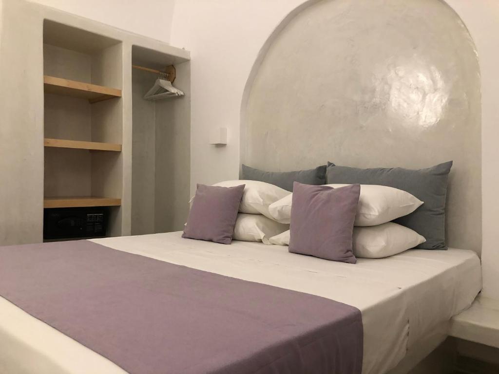 カマリにあるSelena Villaのベッドルーム1室(紫と白の枕が備わるベッド1台付)