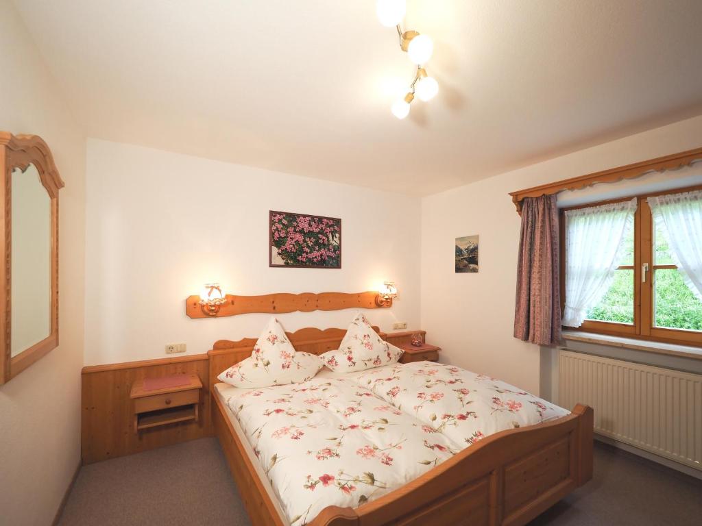 1 dormitorio con cama y ventana en Haus Hölzl Ferienwohnungen, en Ramsau