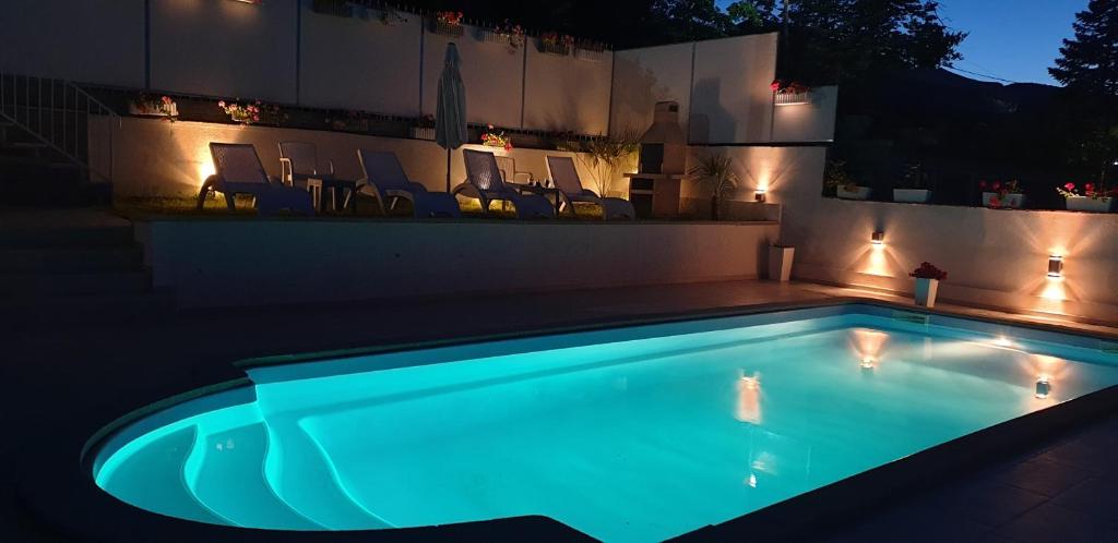 a swimming pool lit up at night with lights at Family House in Star Dojran