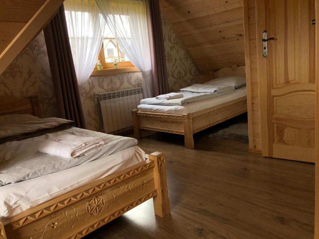 um quarto com 2 camas numa casa de madeira em Domek Tatrzańska Zyngierka em Ząb