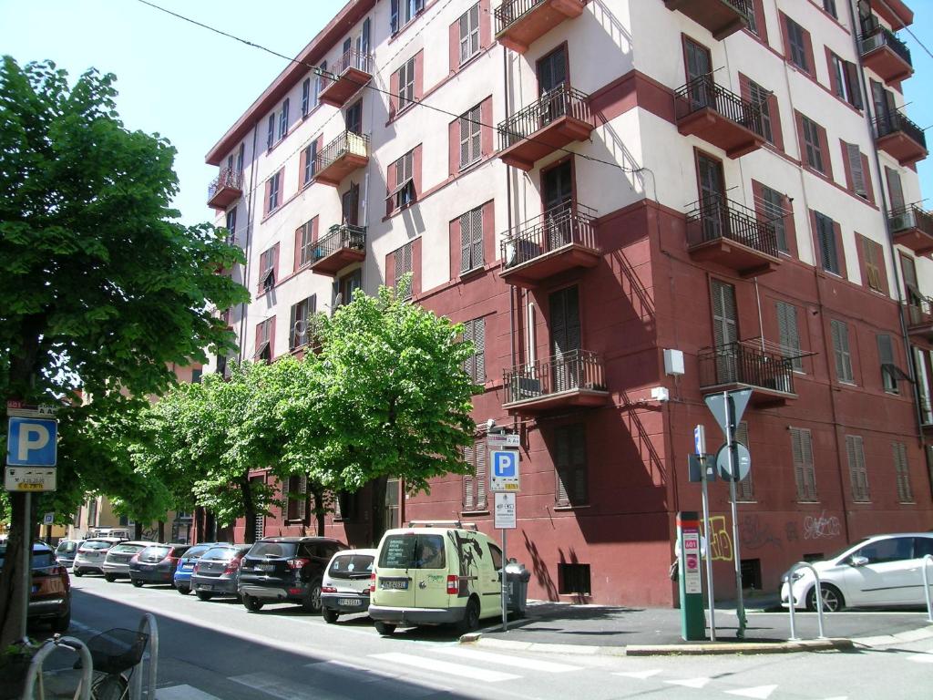 ein rotes Gebäude mit Autos, die an der Straßenseite geparkt sind in der Unterkunft lamarmora9 in La Spezia