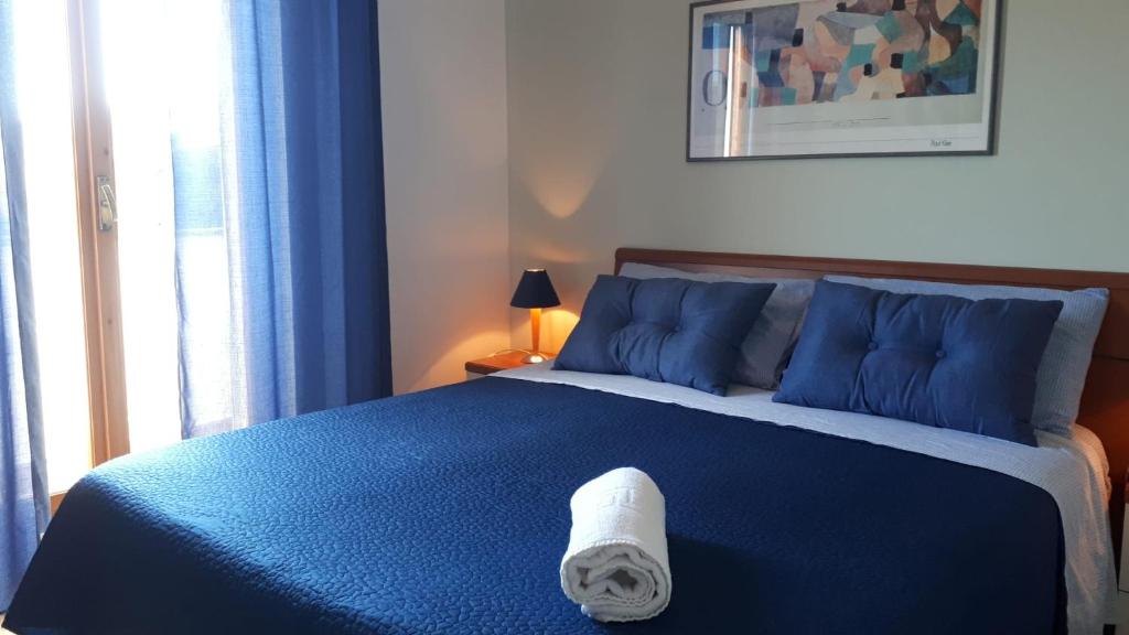 una camera con un letto blu e un asciugamano sopra di Alloggio Turistico IL Bucchero a Porto Clementino