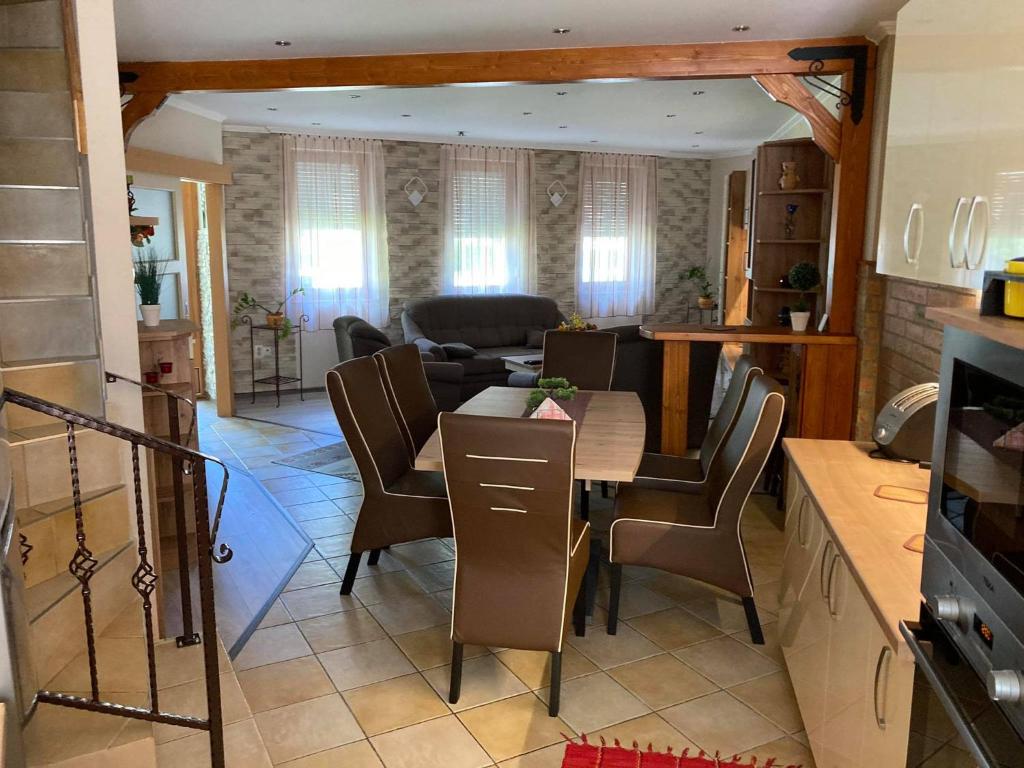 a kitchen and living room with a table and chairs at Boróka Apartman Gyula in Gyula