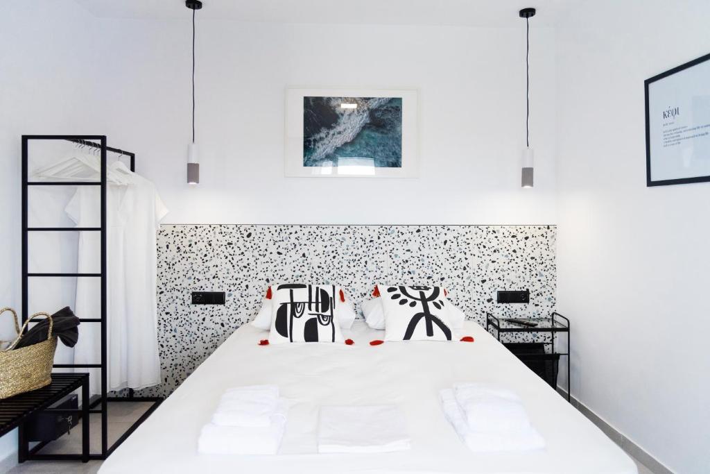 a bedroom with a white bed with black and white wallpaper at Seaside Suites in Kavos